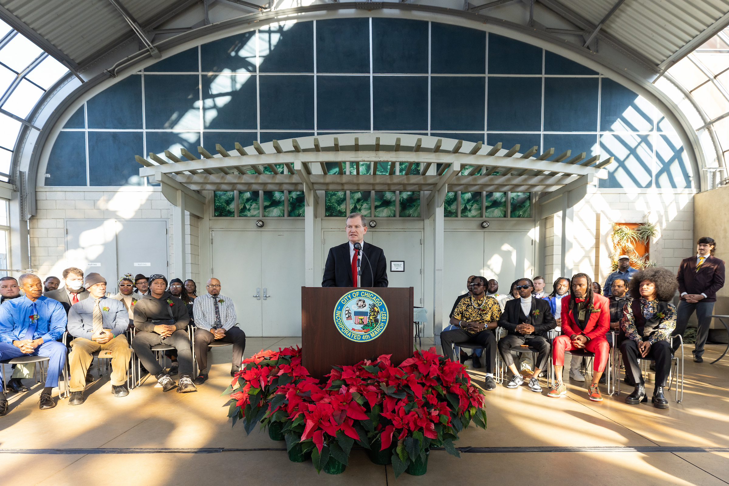 CDOT Acting Commissioner Tom Carney speaks at a podium with Greencorps graduates behind him